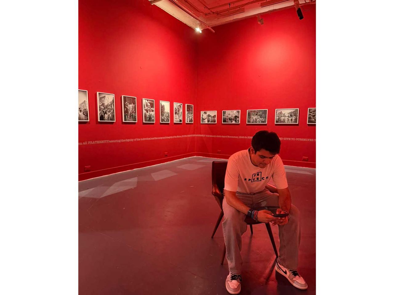 Raihan Vadra in the red-walled gallery room of his 'No Idea Is Final' exhibition at Bikaner House, New Delhi, surrounded by his protest photographs